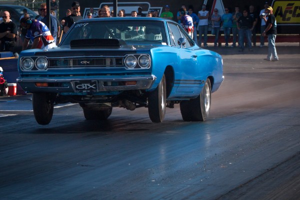 vintage plymouth gtx launching at a drag race