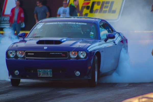 late model dodge challenger doing a burnout during a drag race