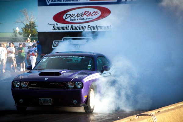 late model dodge challenger doing a burnout during a drag race