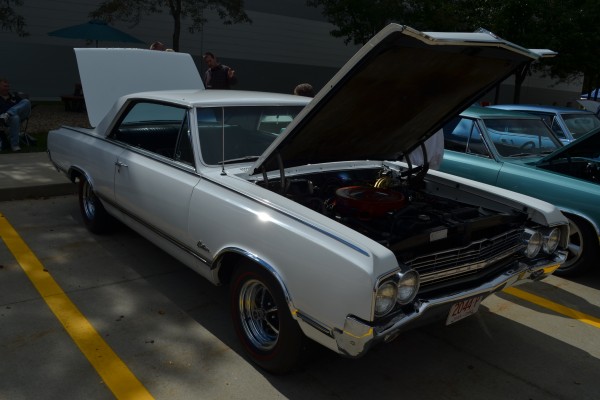 white oldsmobile cutlass coupe at a car show