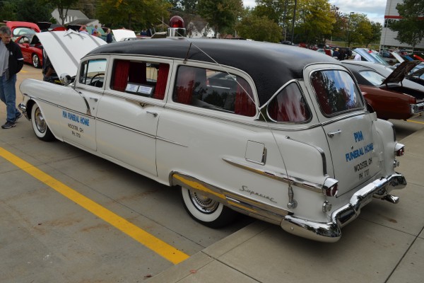 vintage 1956 pontiac hearse in funeral home livery at a car show