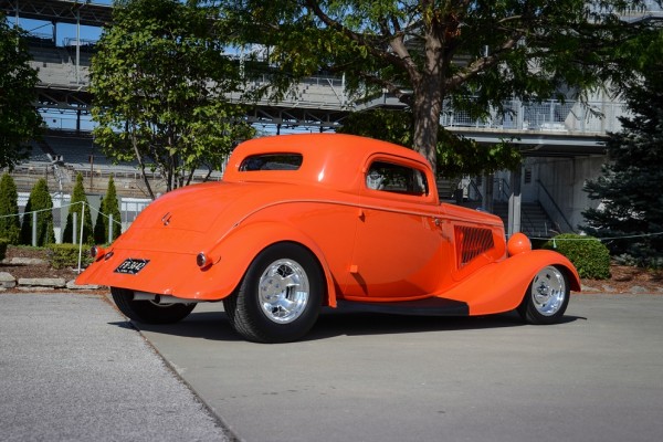 rear quarter view of an orange ford hot rod coupe