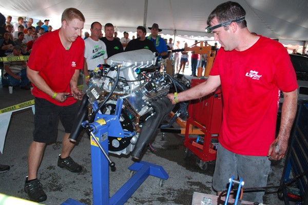 two men working on a gm ls engine during a contest