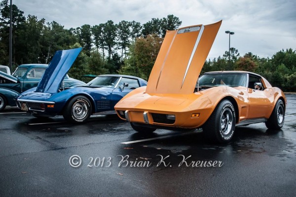a pair of classic c3 corvette stingrays at a car show
