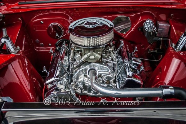 Chromed-out Chevy V8 engine in a classic muscle car