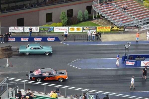 a pair of vintage muscle cars staging before a drag race
