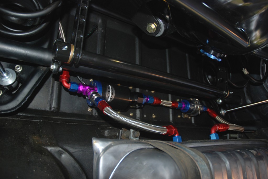 fuel line routing under the chassis of a vintage drag race car