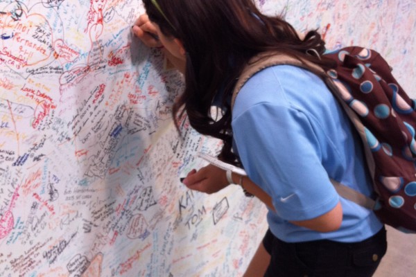 woman signing wall at Carrol Shelby museum