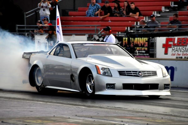 a Cadillac xlr coupe drag car doing a burnout prior to a race