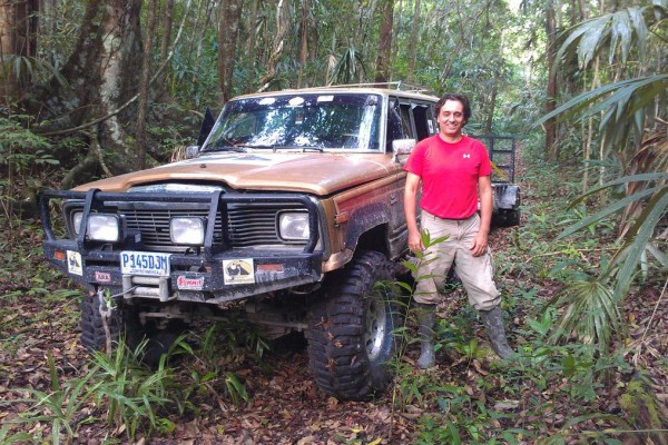 man posing with 1985 Jeep Grand Wagoneer on jungle trail