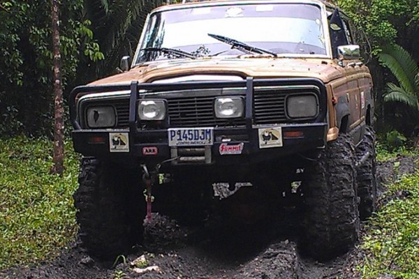 jeep grand wagoneer on a muddy jungle trail