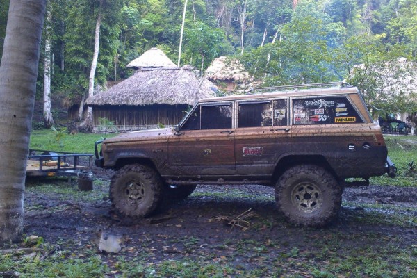 jeep grand wagoneer stopped at a jungle village