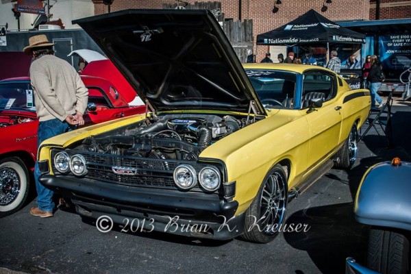 ford torino gt fastback coupe with its hood up at a car show