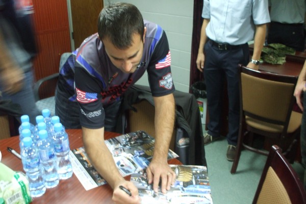 nhra driver signing an autograph for military troops stationed overseas