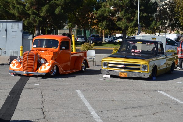 a pair of classic vintage trucks displayed outside at SEMA 2013