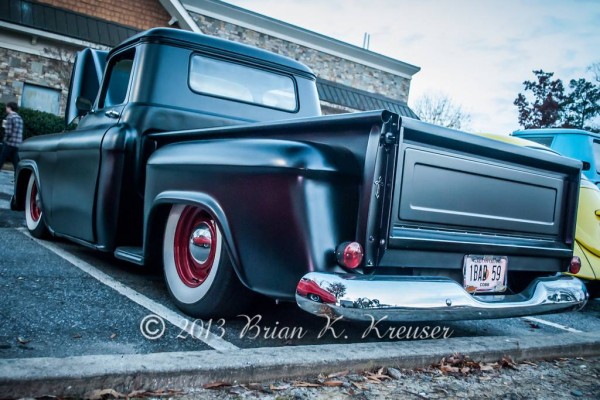 rear view of a flat black chevy hot rod pickup truck