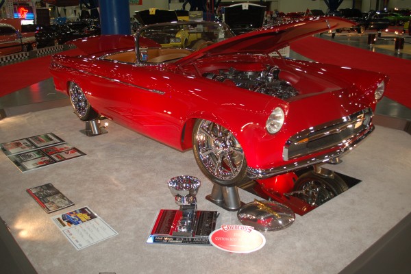 1955 Ford Thunderbird on display with trophy at indoor car show