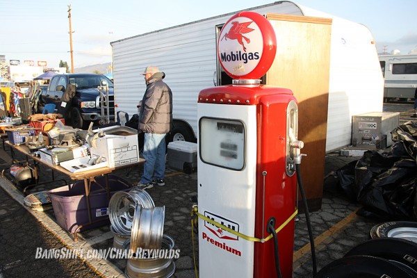 vintage car parts and gas pump at swap meet