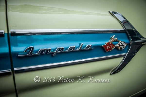 close up of the impala script badge on the fender of a vintage chevy