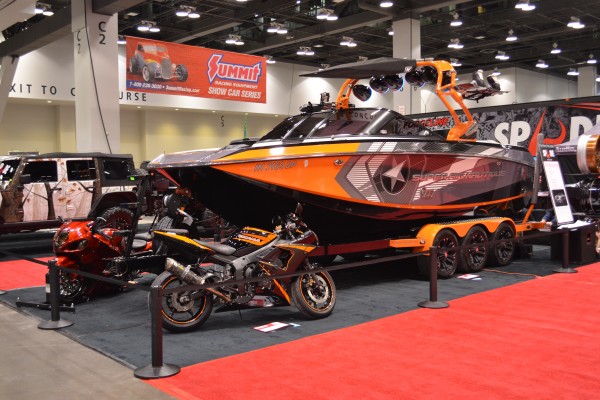 large powersports car show display with speedboat and motorcycles