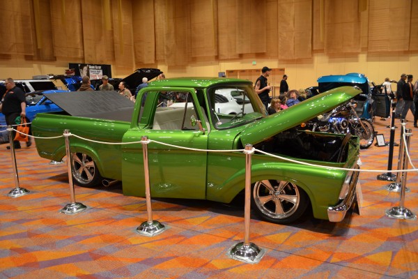 green custom lowrider truck displayed at indoor car show
