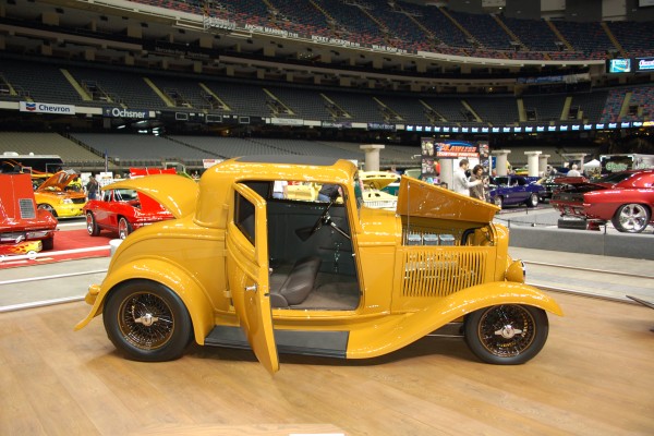 Yellow ford 3 window hot rod coupe Displayed at Indoor Car Show