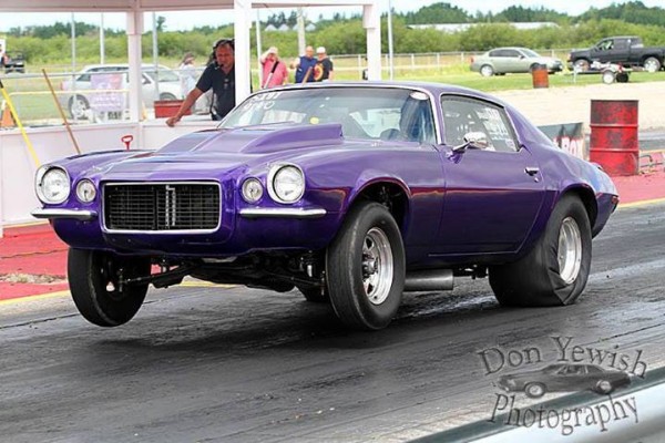 Chevy Camaro second gen RS doing a wheelstand at a dragstrip