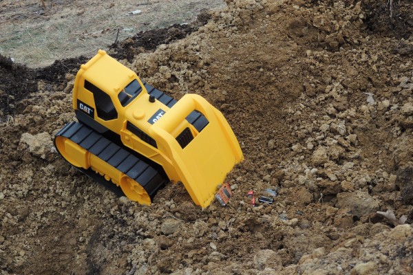 Bulldozer plowing into Toy Cars Buried in Dirt