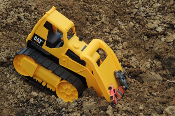 Bulldozer recovering Toy Cars Buried in Dirt