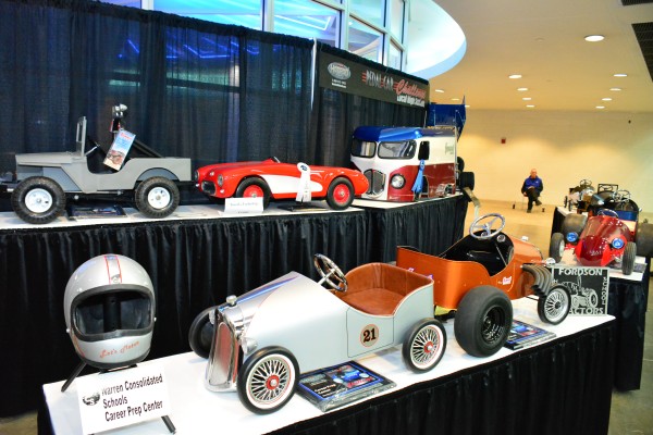 customized pedal cars on display at indoor car show