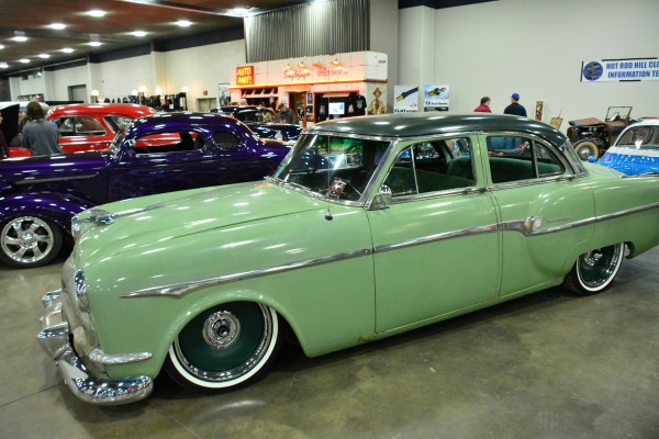 lowered postwar chevy sedan on display at indoor car show