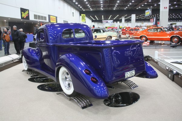 custom blue hot rod rod truck on display at indoor car show