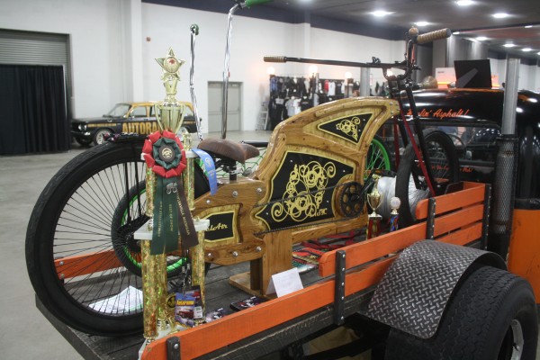 custom wooden bicycle on display at indoor car show