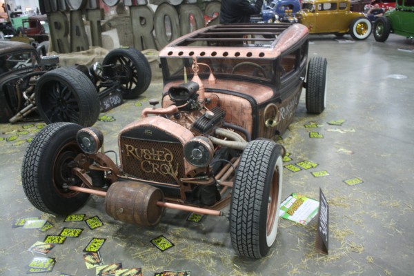 moonshine themed rat rod on display at indoor car show