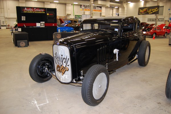 ford five window hot rod coupe on display at indoor car show