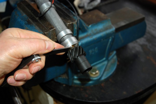 using a feeler gauge to check shim thickness on a distributor shaft