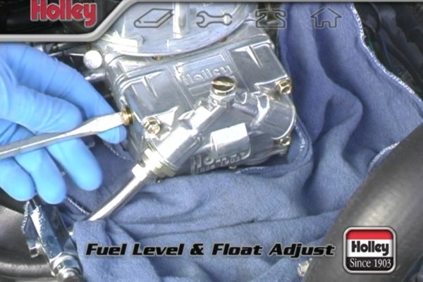 man adjusting float and fuel level on a holley carburetor