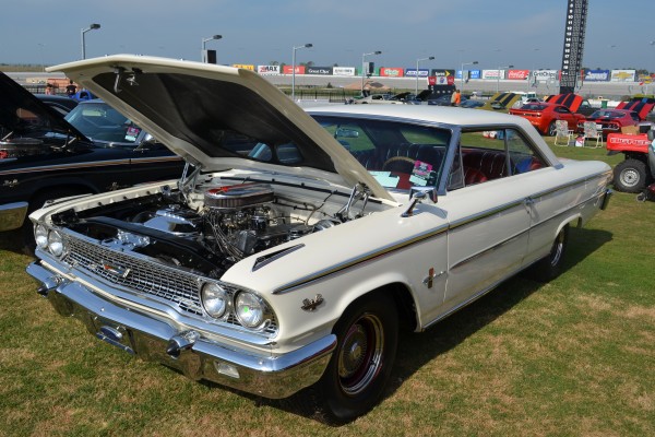vintage white ford fairlane thunderbolt with its hood open