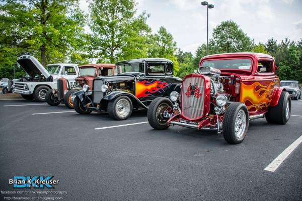 row of classic hot rods at a car show