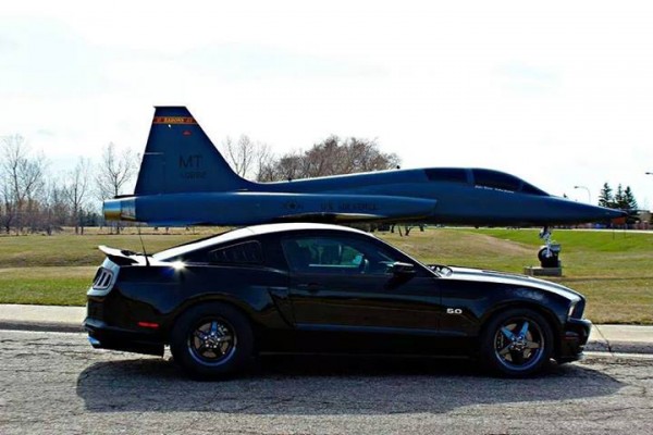 s197 ford mustang next to a static fighter jet display