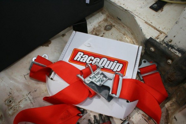 a racequip racing harness and box on the floor of a jeep cj