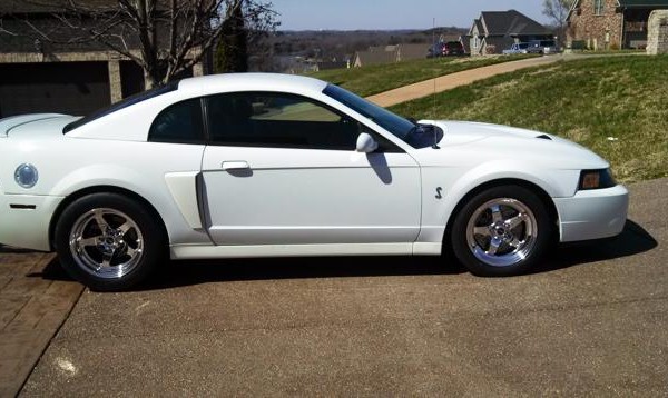 a new edge white sn95 ford mustang cobra in a driveway