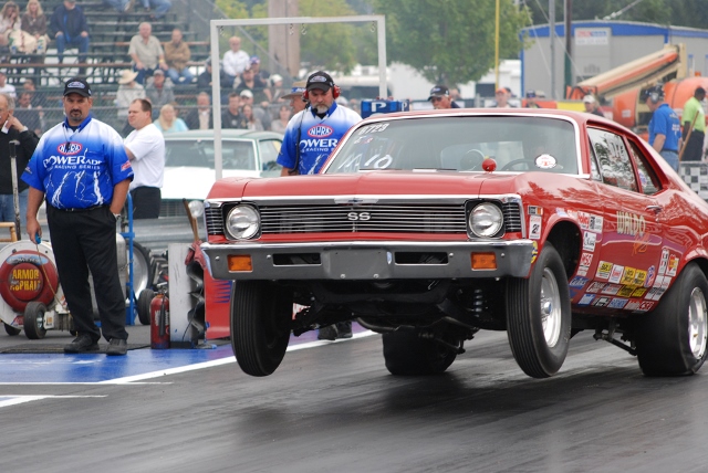 chevy nova ss drag car launching at start of a drag race with wheel stand
