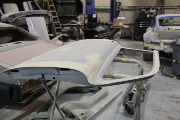 a vintage car door on a rack prior to paint and body work