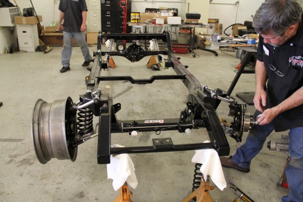 installing suspension parts on a bare hot rod chassis frame