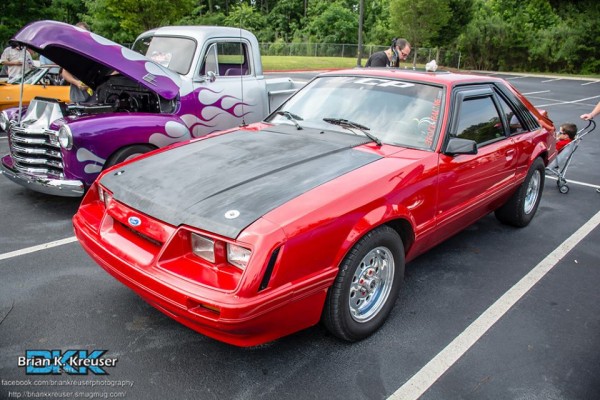 red foxbody ford mustang at a car show