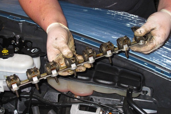 man holding mounted rocker arms for a gm ls engine