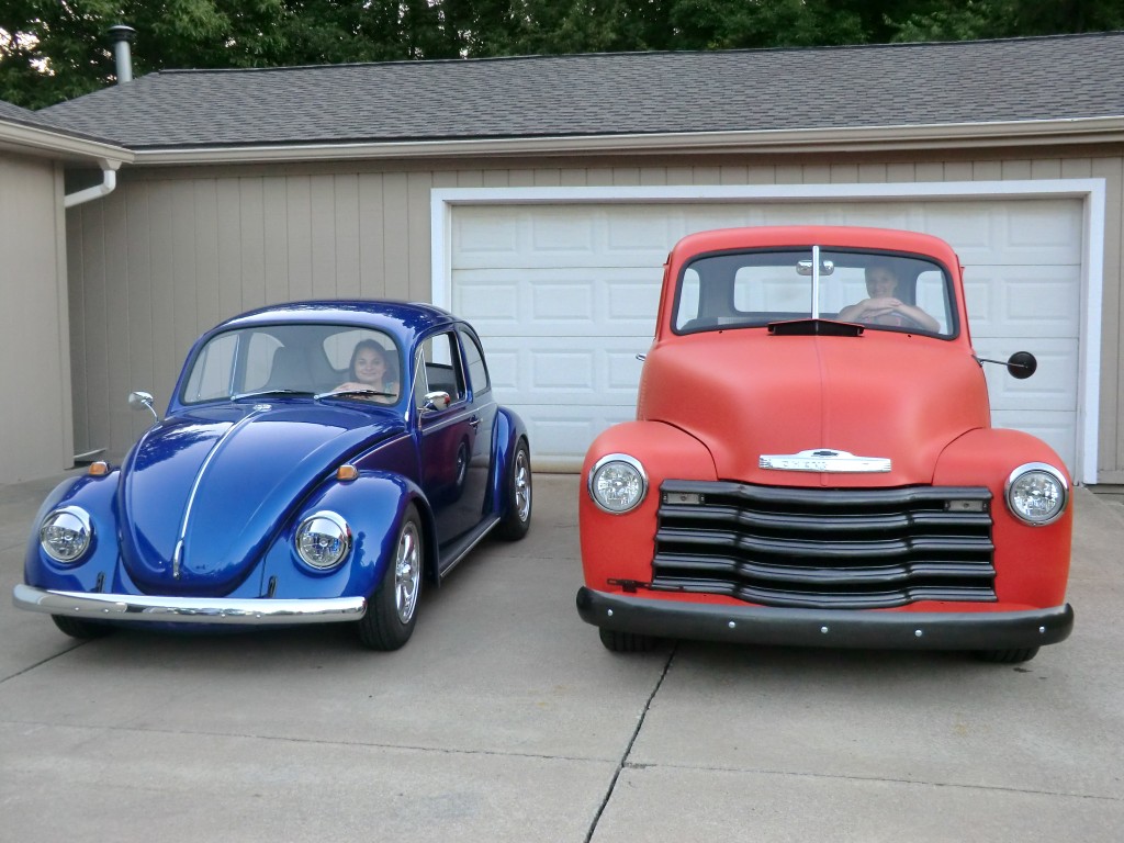 a vintage chevy 3100 truck and vw beetle bug in a driveway