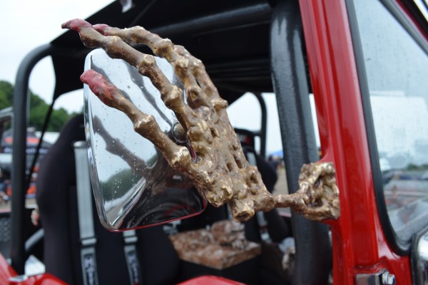 skeleton hand holding mirror of a rat rod truck