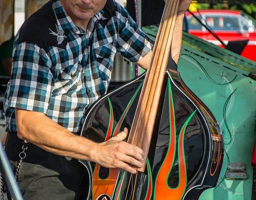 bassist playing rockabilly music during a cruise-in car show